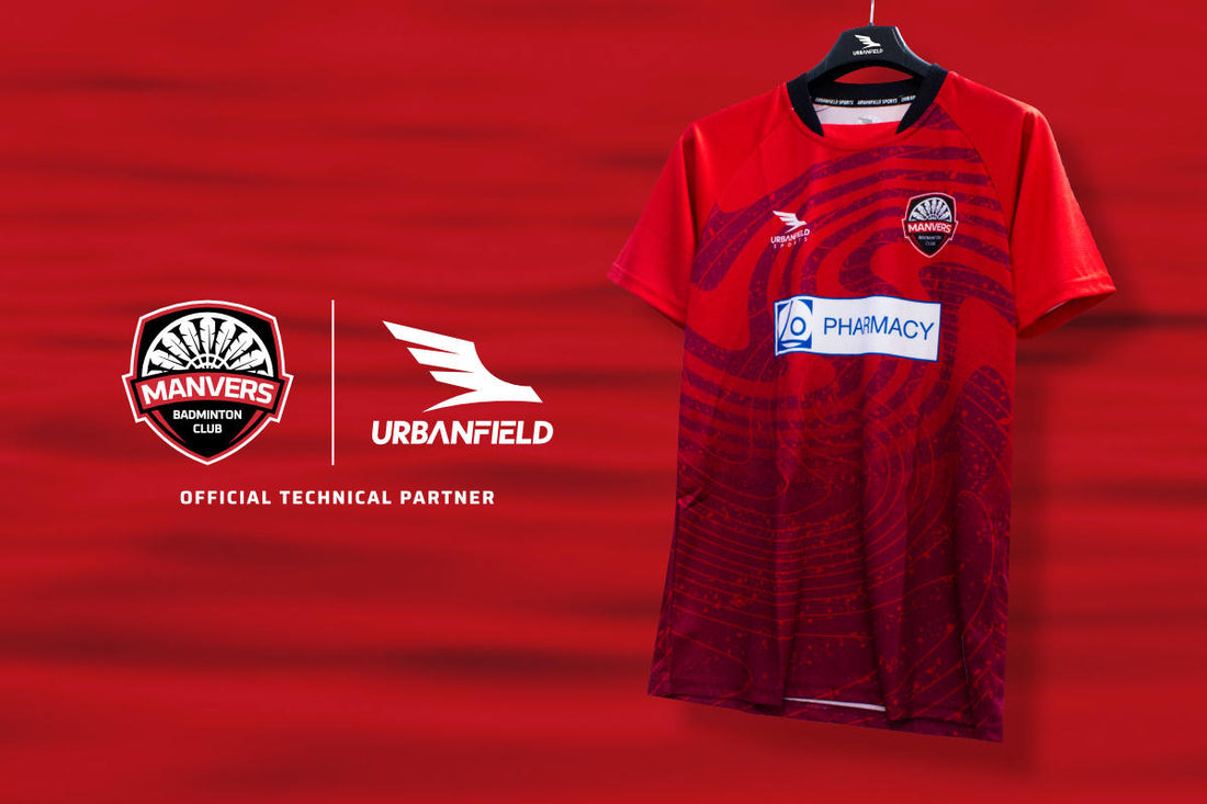 Manvers Badminton Club shirt on a black hanger in front of a red lake background.