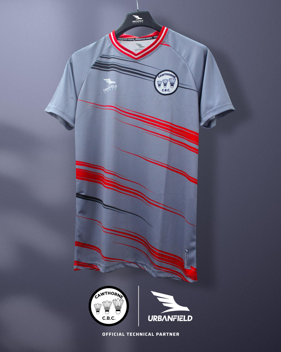 Cawthorne Badminton Club shirt on a black hanger in front of a grey background.