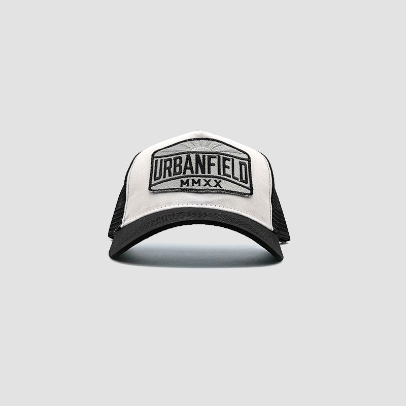 Front view of Urbanfield Sports sunset trucker cap in black and white