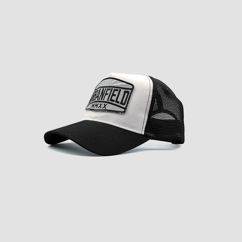 Side view of Urbanfield Sports sunset trucker cap in black and white