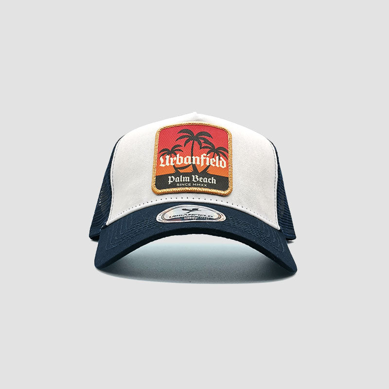Front view of Urbanfield Sports palm beach trucker cap in navy blue and white